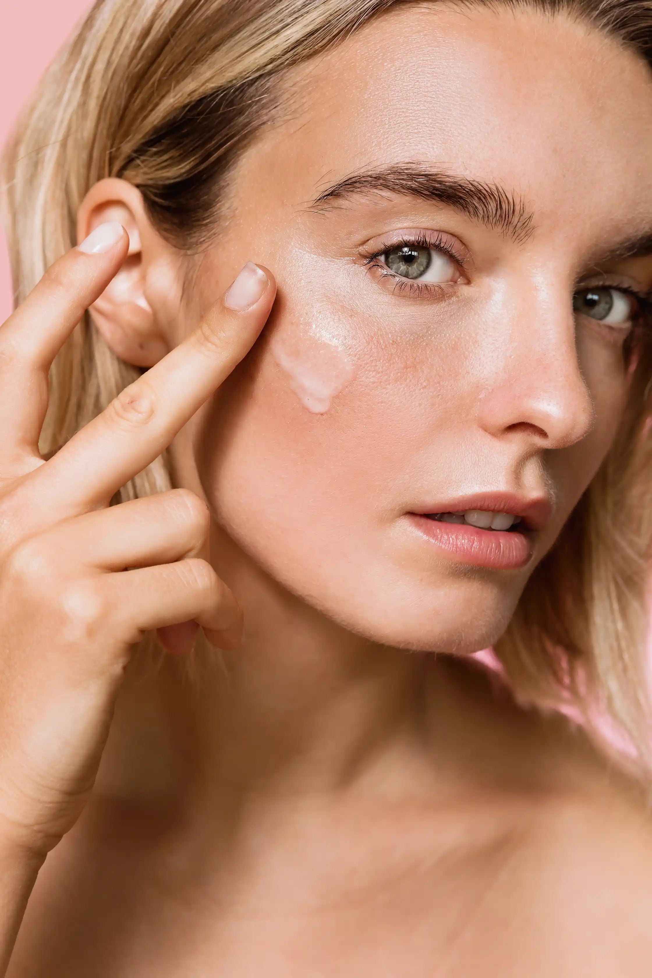 Modelo aplicando el sérum antimanchas de Holisi sobre su rostro